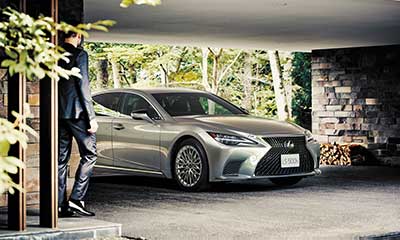 A Lexus LS parked in a garage as a man approaches.