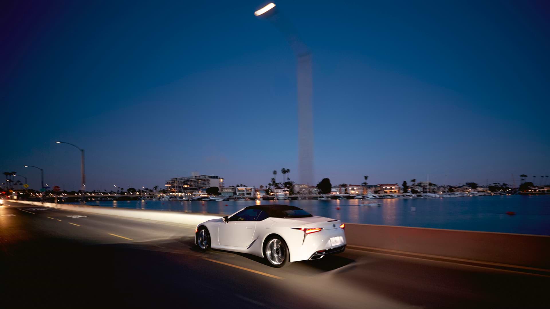 LC 500 Convertible in White Nova shown driving at dusk