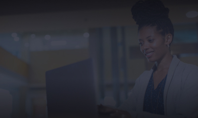 Woman smiling at a laptop screen