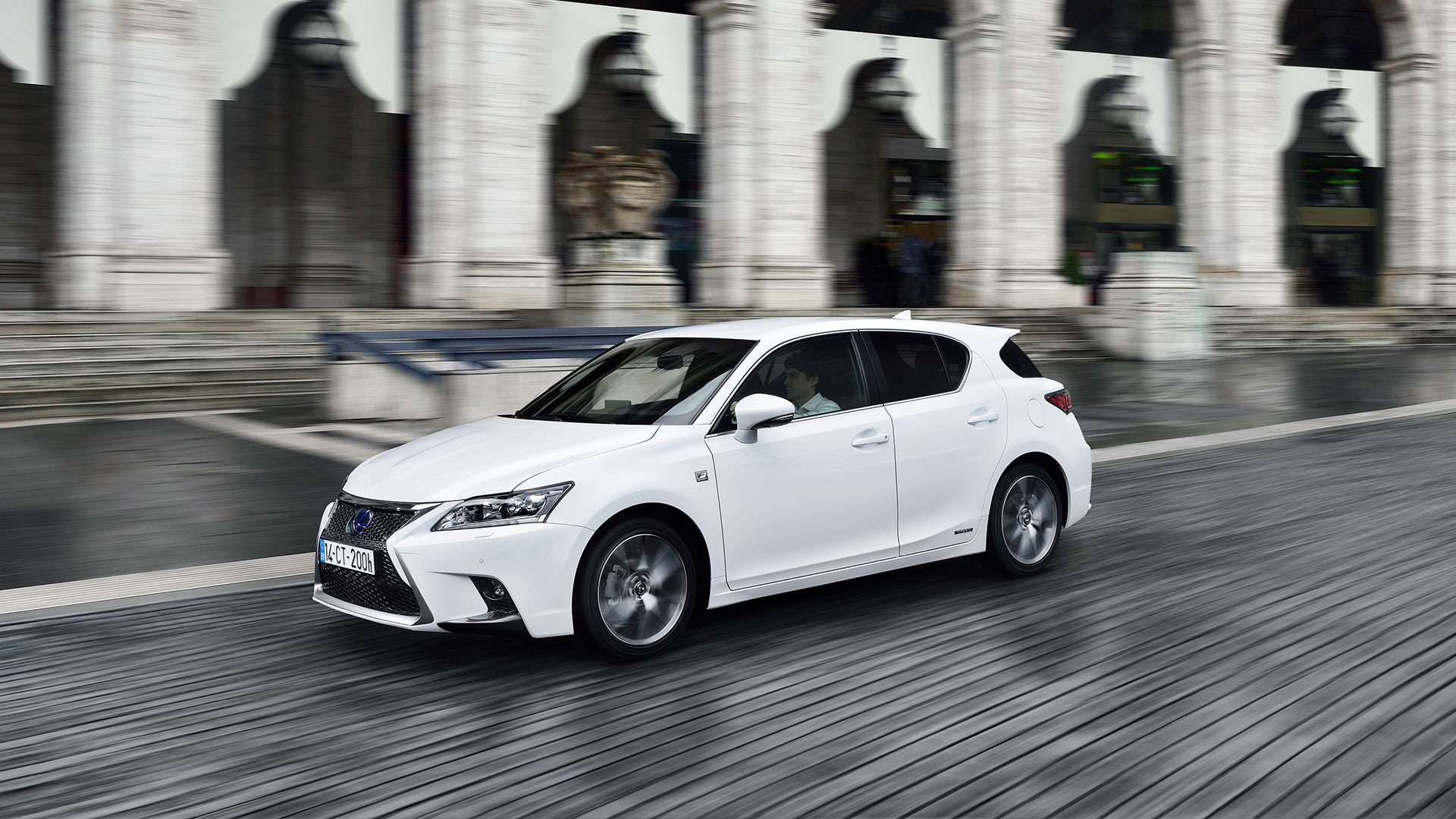 White Lexus CT 200h driving along a wooden boardwalk