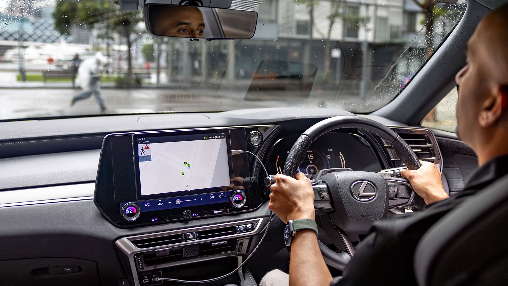 A man drives a Lexus vehicle through a city