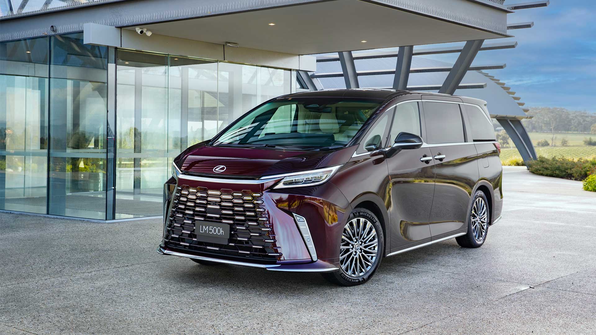 Lexus LM 500h Ultra Luxury vehicle parked in front of a building.
