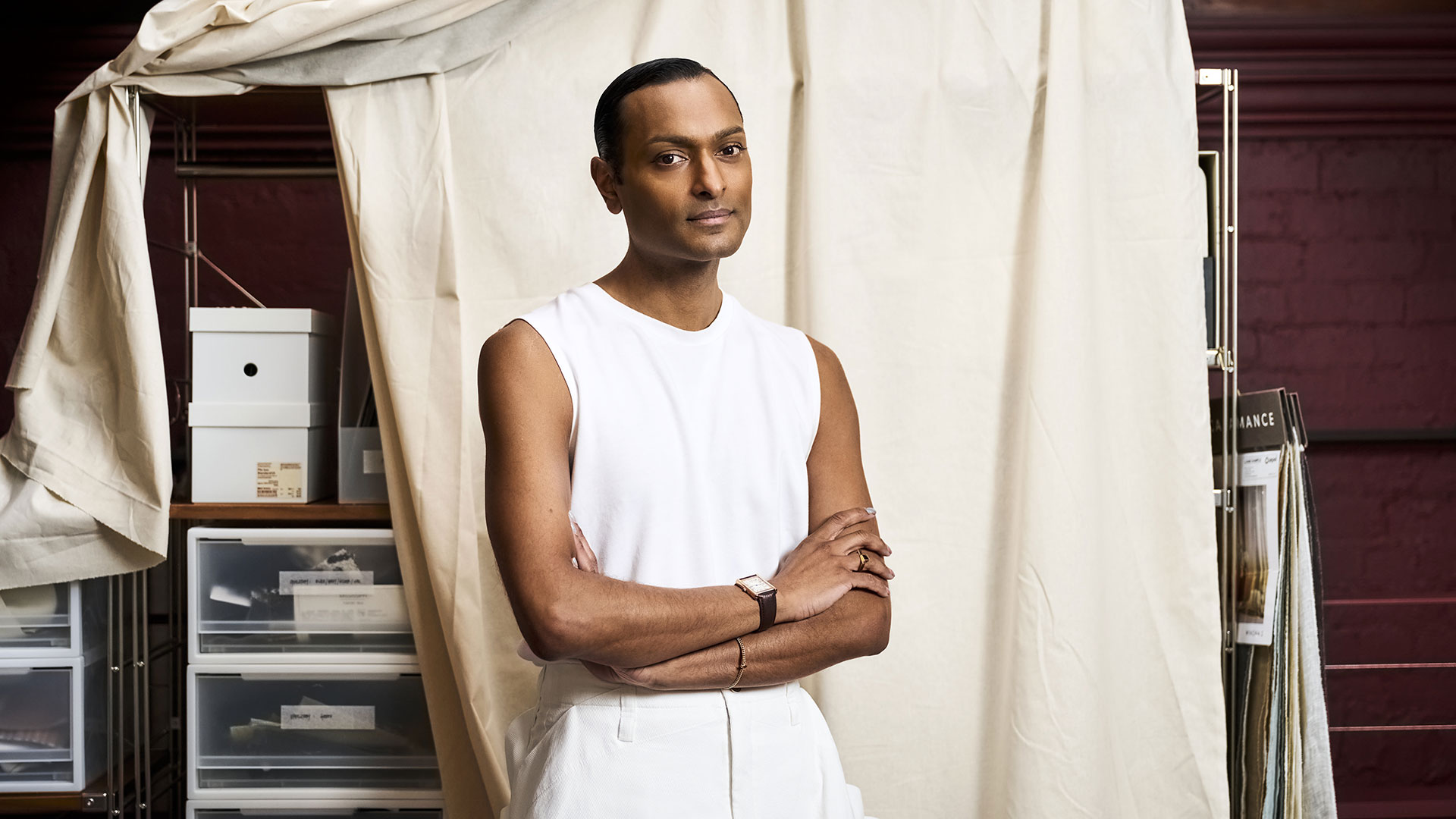 Designer Brahman Perera standing with arms crossed in a studio environment