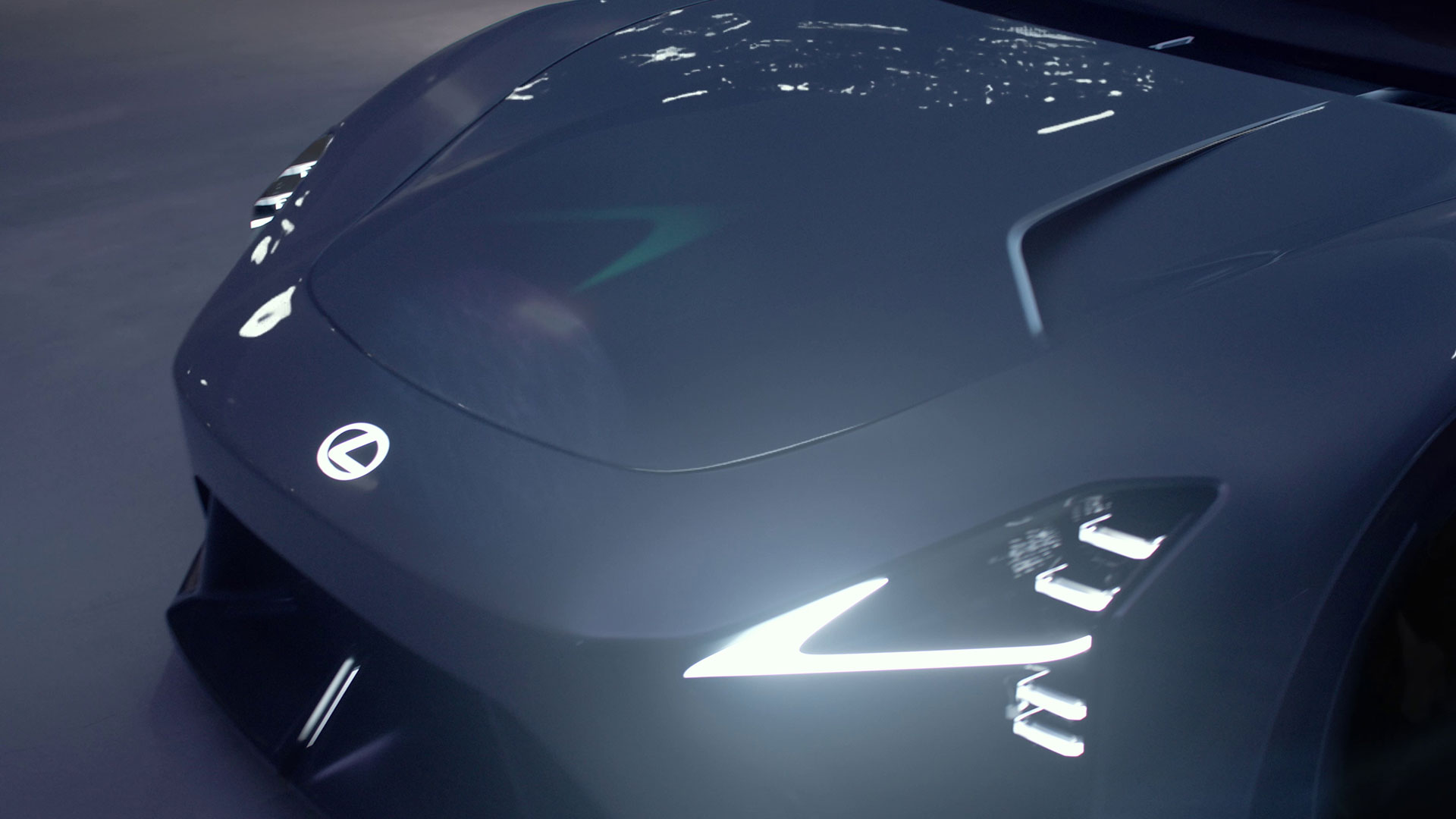 Dark grey Lexus LFA Concept BEV sports car front detail showing illuminated headlights and sculpted bonnet