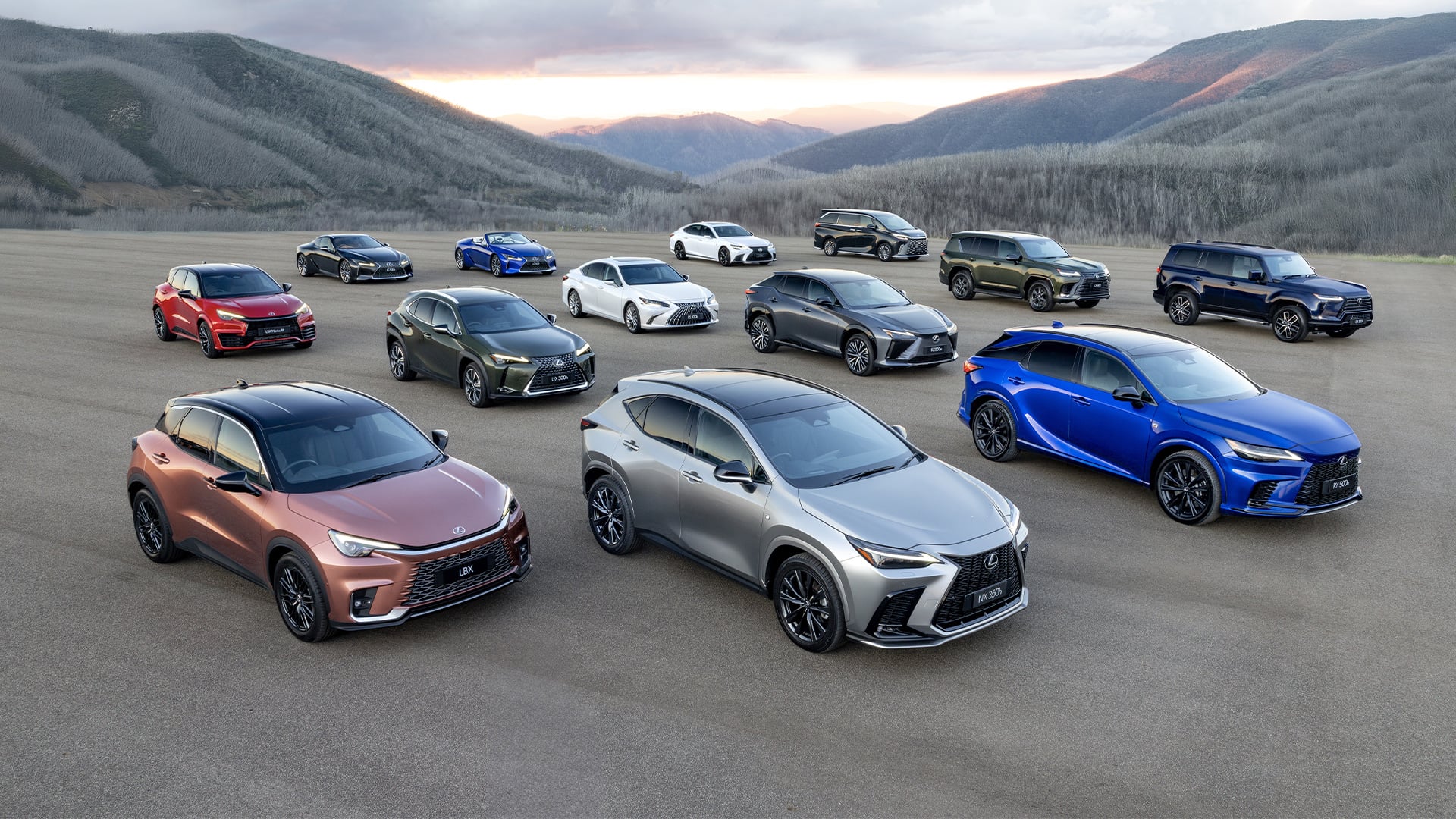 Lexus vehicle lineup including SUVs and sedans displayed on open landscape with mountain backdrop